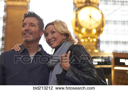 Stock Image - Caucasian couple hugging in Grand Central Station, New York City, New York, United States. Fotosearch