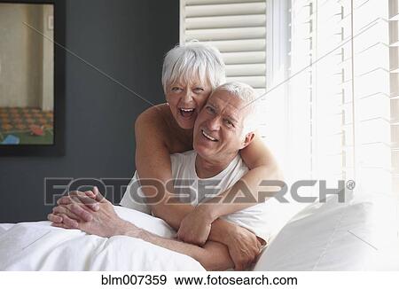 Caucasian couple hugging on bed View Large Photo Image Stock Photo - Caucasian couple hugging on bed. Fotosearch
