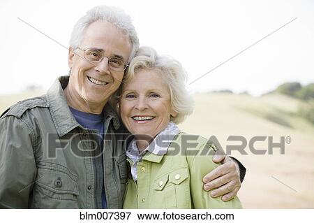 Stock Photo - Caucasian couple hugging outdoors. Fotosearch