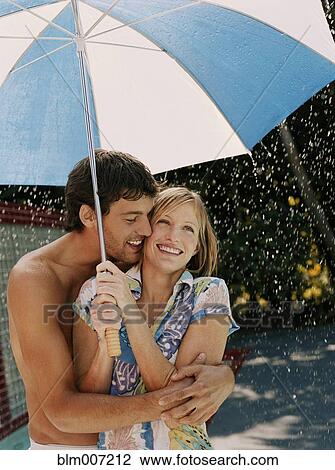 Caucasian couple hugging under umbrella View Large Photo Image Stock Image - Caucasian couple hugging under umbrella. Fotosearch
