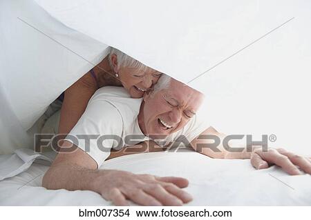 Caucasian couple playing under sheet in bed View Large Photo Image Picture - Caucasian couple playing under sheet in bed. Fotosearch