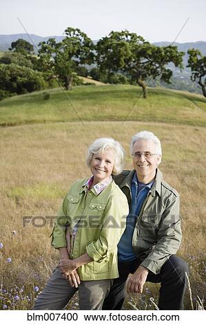 Stock Image - Caucasian couple standing in field. Fotosearch