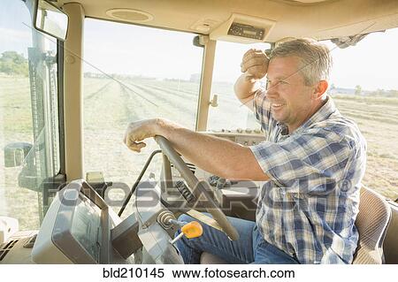 Stock Photography - Caucasian farmer driving tractor. Fotosearch