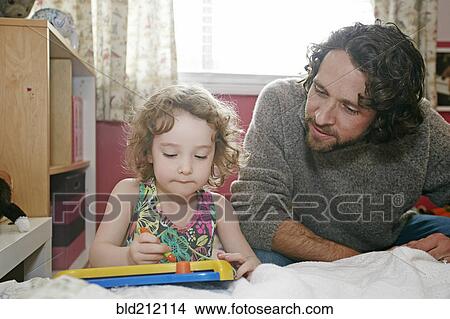 Caucasian father and daughter playing in bedroom View Large Photo Image Picture - Caucasian father and daughter playing in bedroom. Fotosearch