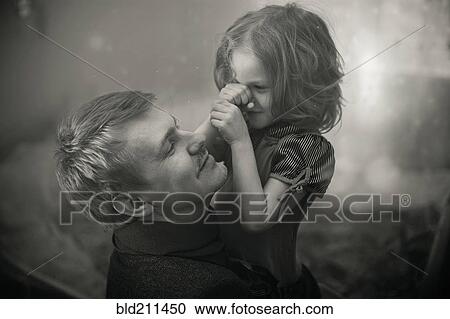 Stock Image - Caucasian father and daughter playing outdoors. Fotosearch
