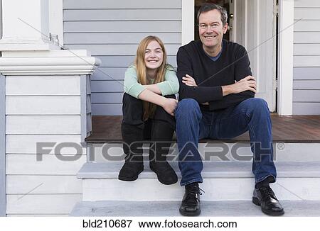 Stock Photo - Caucasian father and daughter smiling on steps. Fotosearch