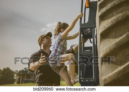 Stock Image - Caucasian father and daughter working on farm. Fotosearch