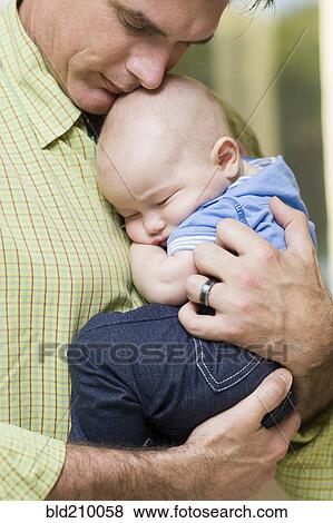 Caucasian father holding baby boy View Large Photo Image Stock Photo - Caucasian father holding baby boy. Fotosearch