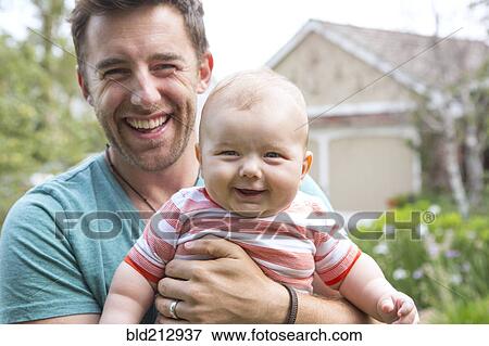 Caucasian father holding baby outdoors View Large Photo Image Stock Photo - Caucasian father holding baby outdoors. Fotosearch