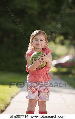 Caucasian girl holding watermelon on sidewalk View Large Photo Image Picture - Caucasian girl holding watermelon on sidewalk. Fotosearch
