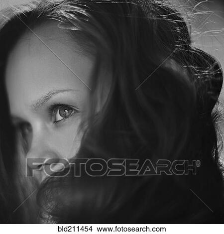 Picture - Caucasian girl peering over her hair. Fotosearch
