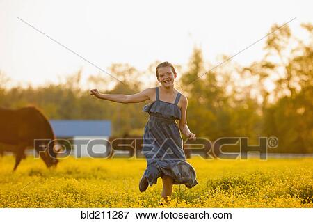 Stock Photo - Caucasian girl running in field of flowers. Fotosearch