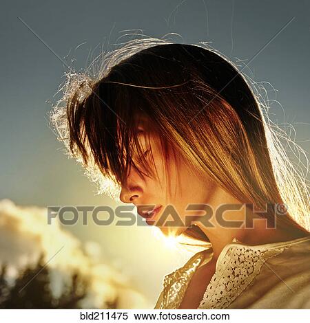 Stock Photography - Caucasian girl standing in sun outdoors. Fotosearch
