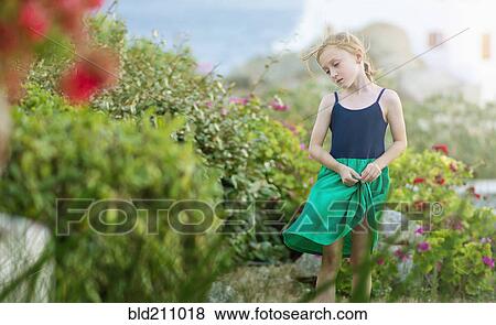 Stock Photo - Caucasian girl walking in field of flowers. Fotosearch