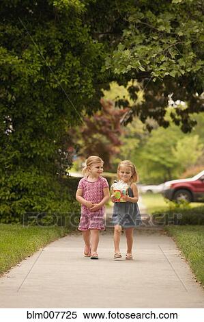 Stock Photography - Caucasian girl walking on sidewalk with gift. Fotosearch