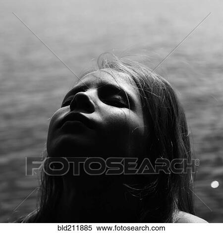 Stock Photography - Caucasian girl with head back by lake. Fotosearch