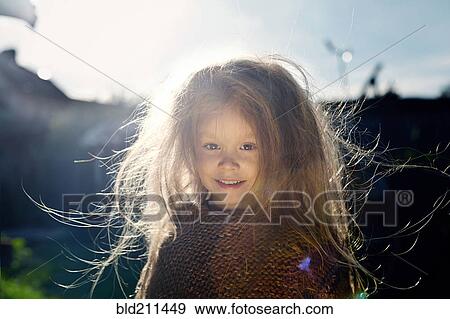 Stock Photo - Caucasian girl with messy hair outdoors. Fotosearch