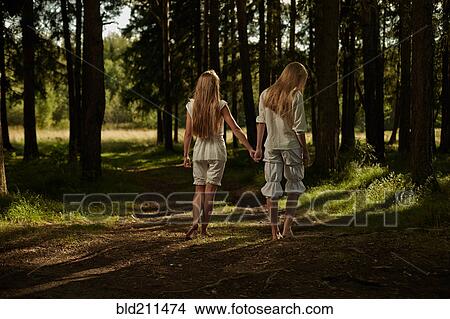 Caucasian girls holding hands in forest View Large Photo Image Picture - Caucasian girls holding hands in forest. Fotosearch