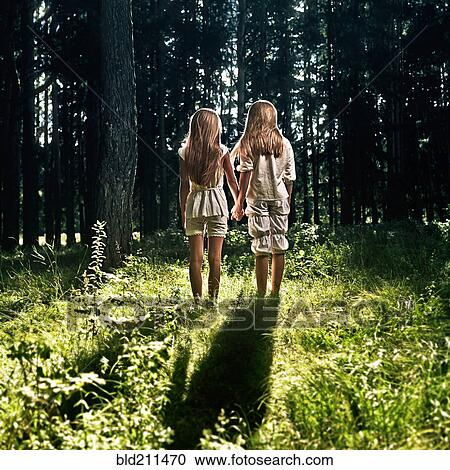 Caucasian girls holding hands in forest View Large Photo Image Stock Image - Caucasian girls holding hands in forest. Fotosearch