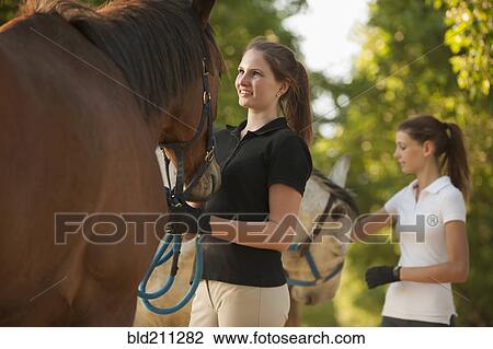 Caucasian girls petting horses in rural landscape View Large Photo Image Stock Image - Caucasian girls petting horses in rural landscape. Fotosearch