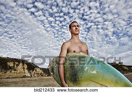 Caucasian man carrying surfboard on beach View Large Photo Image Stock Image - Caucasian man carrying surfboard on beach. Fotosearch