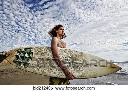 Caucasian man carrying surfboard on beach View Large Photo Image Stock Photography - Caucasian man carrying surfboard on beach. Fotosearch