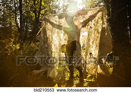 Stock Image - Caucasian man holding fabric outdoors. Fotosearch