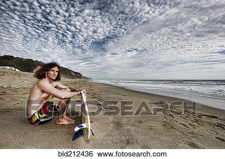 Caucasian man holding surfboard on beach View Large Photo Image Stock Photograph - Caucasian man holding surfboard on beach. Fotosearch