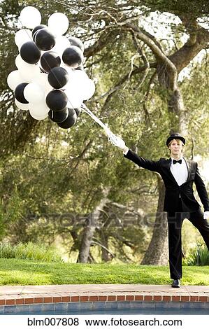 Caucasian man in tuxedo holding bunch of balloons View Large Photo Image Stock Photo - Caucasian man in tuxedo holding bunch of balloons. Fotosearch