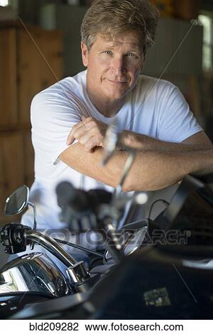 Caucasian man on motorcycle in garage View Large Photo Image Stock Image - Caucasian man on motorcycle in garage. Fotosearch