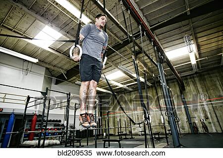 Caucasian man on rings in gym View Large Photo Image Stock Photography - Caucasian man on rings in gym. Fotosearch