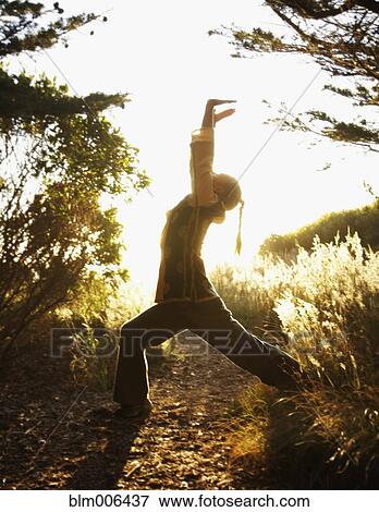 Stock Photo - Caucasian man practicing tai-chi in remote area. Fotosearch