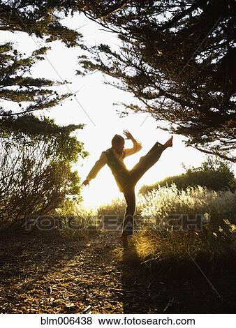 Stock Photo - Caucasian man practicing tai-chi in remote area. Fotosearch