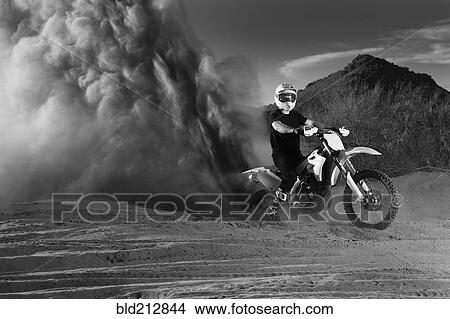 Caucasian man riding dirt bike in dust cloud View Large Photo Image Picture - Caucasian man riding dirt bike in dust cloud. Fotosearch