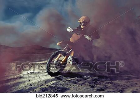 Stock Photography - Caucasian man riding dirt bike in dust cloud. Fotosearch