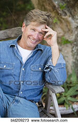 Caucasian man sitting outdoors View Large Photo Image Stock Image - Caucasian man sitting outdoors. Fotosearch