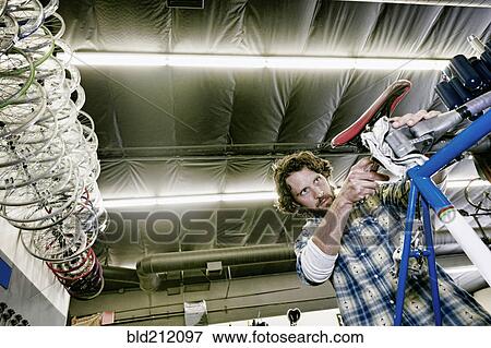 Caucasian man smiling in bicycle repair shop View Large Photo Image Stock Photo - Caucasian man smiling in bicycle repair shop. Fotosearch