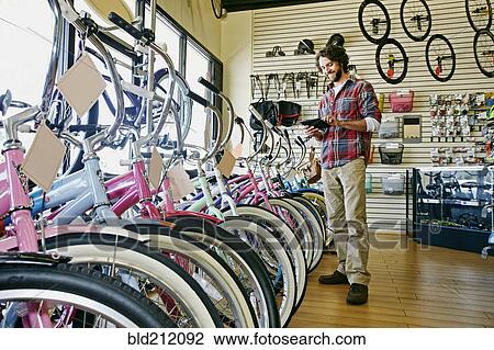 Caucasian man working in bicycle shop View Large Photo Image Stock Image - Caucasian man working in bicycle shop. Fotosearch