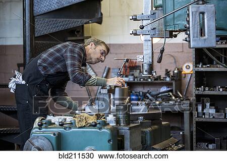 Caucasian man working in metal shop View Large Photo Image Stock Image - Caucasian man working in metal shop. Fotosearch