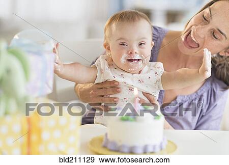 Caucasian mother and baby girl with Down Syndrome celebrating birthday View Large Photo Image Stock Photo - Caucasian mother and baby girl with Down Syndrome celebrating birthday. Fotosearch