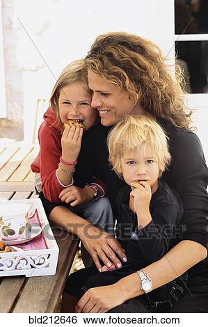 Stock Photograph - Caucasian mother and children eating outdoors. Fotosearch