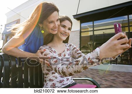 Caucasian mother and daughter taking self-portrait View Large Photo Image Stock Image - Caucasian mother and daughter taking self-portrait. Fotosearch