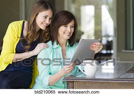 Stock Photography - Caucasian mother and daughter using digital tablet. Fotosearch
