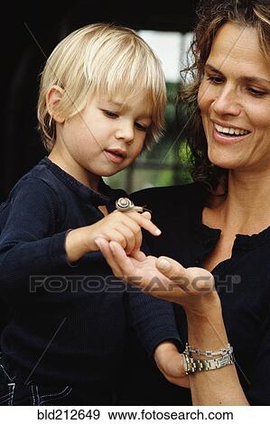 Caucasian mother and son examining snail View Large Photo Image Stock Photo - Caucasian mother and son examining snail. Fotosearch