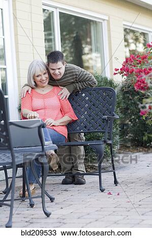 Stock Image - Caucasian mother and son using laptop outdoors. Fotosearch