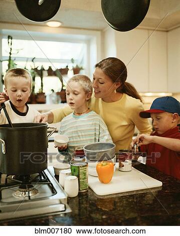 Stock Image - Caucasian mother and sons preparing food. Fotosearch