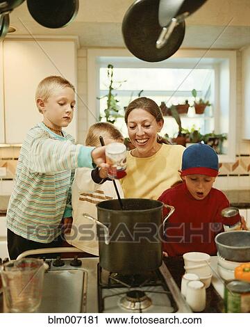 Stock Image - Caucasian mother and sons preparing food. Fotosearch