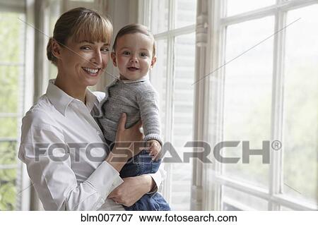 Caucasian mother holding baby View Large Photo Image Stock Photo - Caucasian mother holding baby. Fotosearch