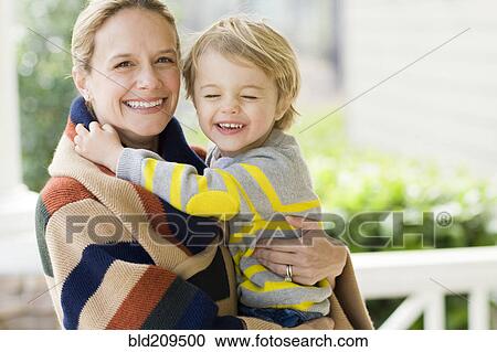 Stock Image - Caucasian mother holding son. Fotosearch