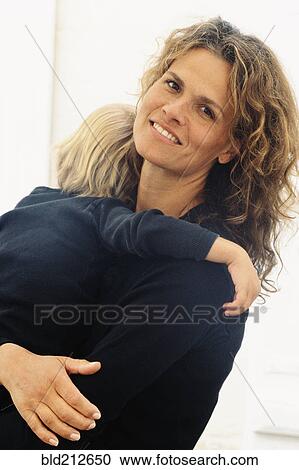 Stock Image - Caucasian mother holding son. Fotosearch